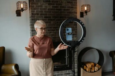 Starsza kobieta sterująca inteligentnym oświetleniem za pomocą głosu w nowoczesnym salonie.