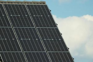 Panele fotowoltaiczne na dachu nowoczesnego domu pasywnego, symbolizujące niezależność energetyczną i energooszczędność.