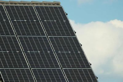 Panele fotowoltaiczne na dachu nowoczesnego domu pasywnego, symbolizujące niezależność energetyczną i energooszczędność.