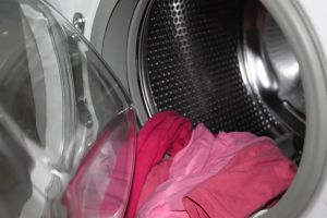 Nowoczesna pralka z otwartymi drzwiami, symbolizująca efektywność energetyczną i recykling wody.