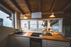 Nowoczesny piekarnik energooszczędny w eleganckiej, drewnianej kuchni, oświetlonej naturalnym światłem.