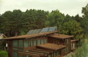 Nowoczesny dom z panelami fotowoltaicznymi na dachu, symbolizujący samowystarczalność energetyczną