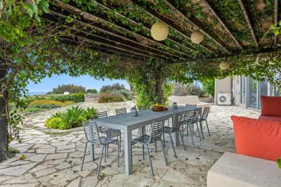 Nowoczesny taras z pergolą porośniętą pnączami, tworzący zieloną ścianę