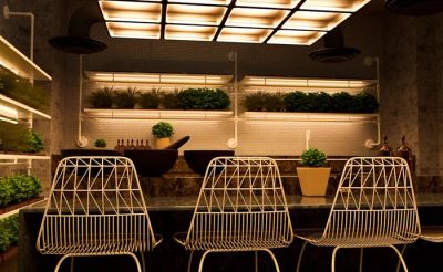 Modułowe meble ogrodowe z syntetycznego rattanu z wbudowanym oświetleniem LED, na tarasie, symbolizujące inteligentne rozwiązania.