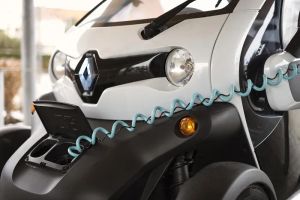 Panele fotowoltaiczne na dachu domu generujące zieloną energię do ładowania samochodu elektrycznego w garażu.