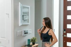 Kobieta ćwicząca przed inteligentnym lustrem fitness w nowoczesnym wnętrzu domu pasywnego