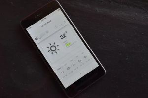 Osoba sterująca inteligentnym oświetleniem LED w domu za pomocą aplikacji mobilnej na smartfonie.
