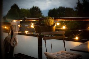 Aplikacja smart home sterująca oświetleniem LED zadaszenia tarasu, widocznego w tle.