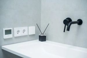 Nowoczesny, czarny panel dotykowy inteligentnej toalety z ikonami funkcji higienicznych.