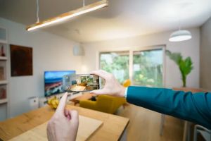 Smartfon z aplikacją do sterowania inteligentnym oświetleniem w nowoczesnym domu