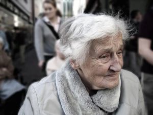 Uśmiechnięta starsza kobieta korzystająca z tabletu w inteligentnym domu