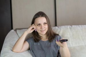 Kobieta sterująca inteligentnym domem za pomocą smartfona, zarządzająca systemami domowymi.