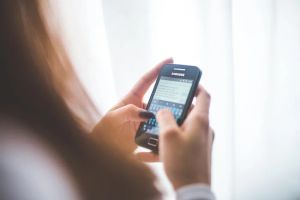 Kobieta używająca tabletu do zarządzania systemem nawadniania roślin w ogrodzie.