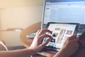 Kobieta korzystająca z tabletu w nowoczesnej, inteligentnej kuchni, symbolizująca komfort i technologię