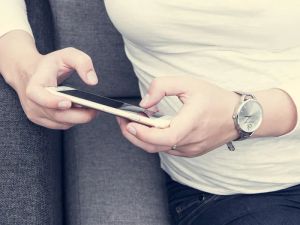 Kobieta korzystająca z tabletu do sterowania inteligentnym oświetleniem w garderobie